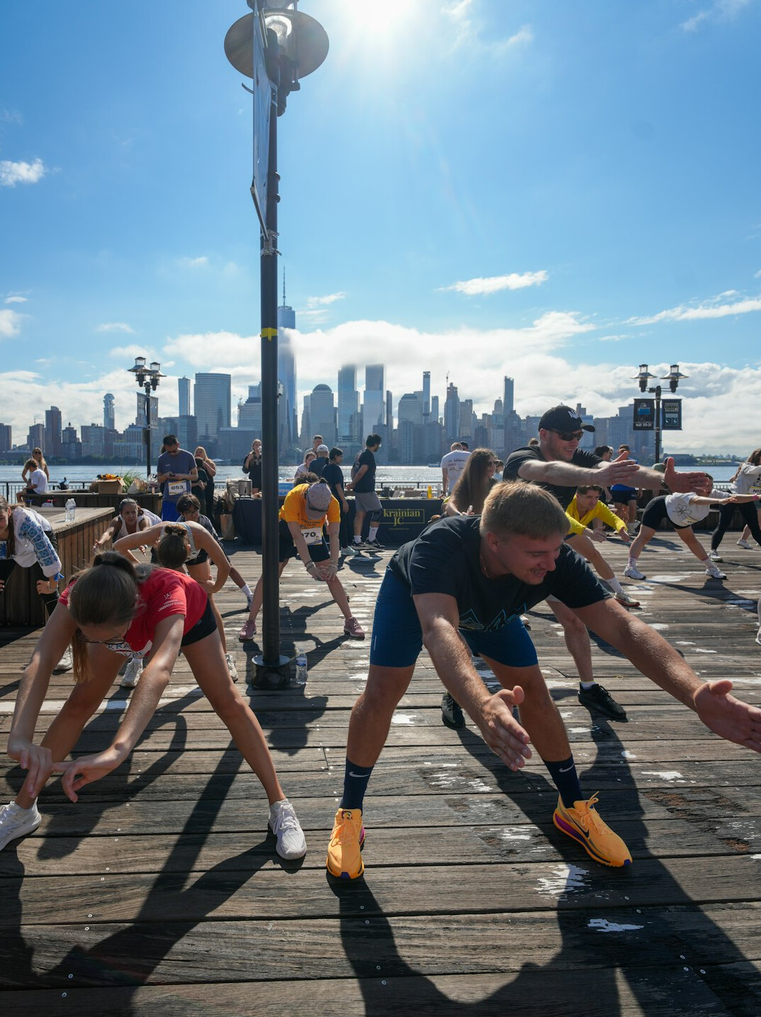 Group of people doing a stretching exercise together outdoors in daylight